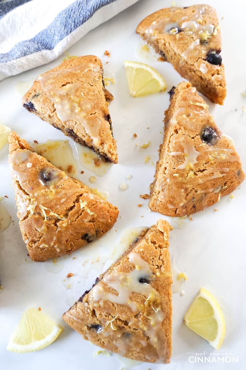 overhead shot of glazed lemon blueberry scones made with almond flour on a white countertop