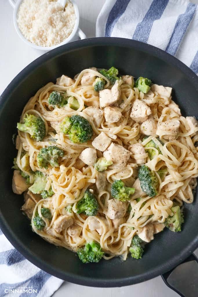 overhead shot of Broccoli Chicken Fettuccine with Cauliflower Alfredo pasta sauce in a black skillet 