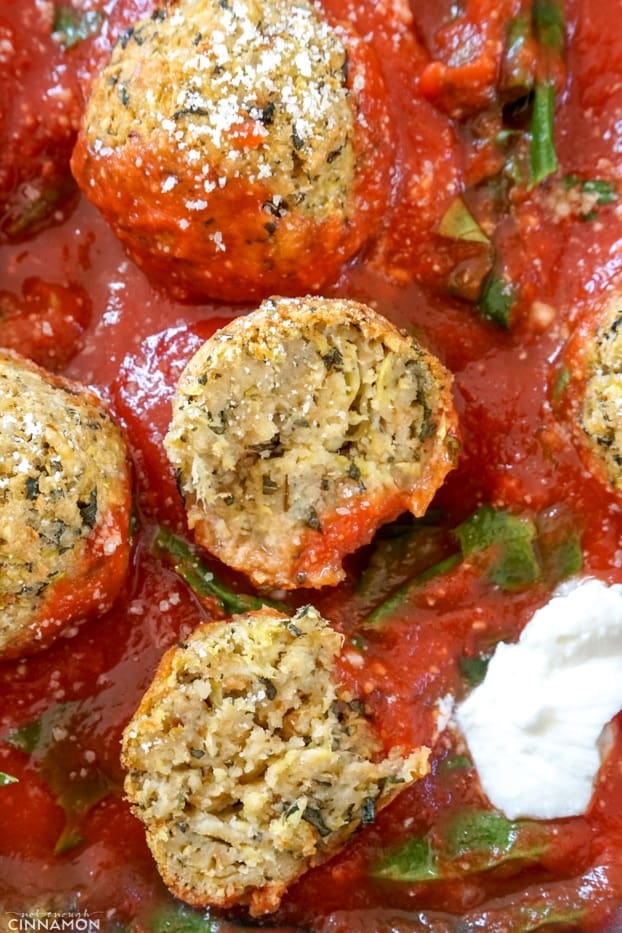 Zucchini meatballs in marinara sauce cut in half to show inside