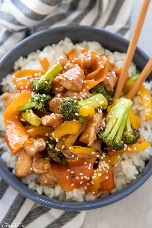 overhead shot of 5-Spice Chicken & Vegetable Stir-Fry served over jasmine rice on a grey plate