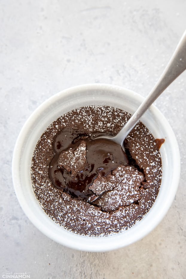 overhead shot of a gluten-free and refined sugar-free molten chocolate lava cake with a spoon digging into the runny center