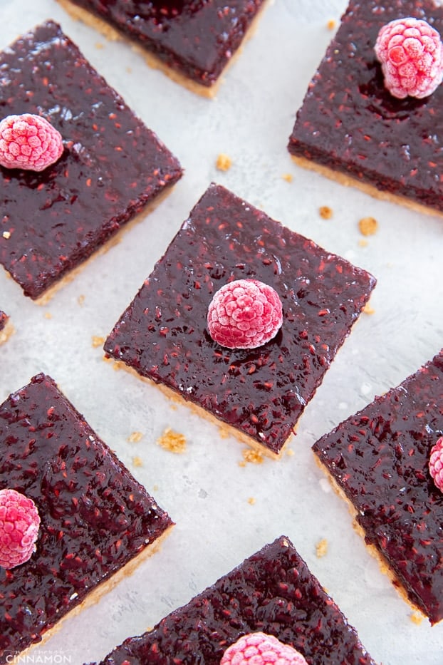 overhead shot of healthy almond butter bars topped with a refined sugar-free raspberry jam and fresh raspberries