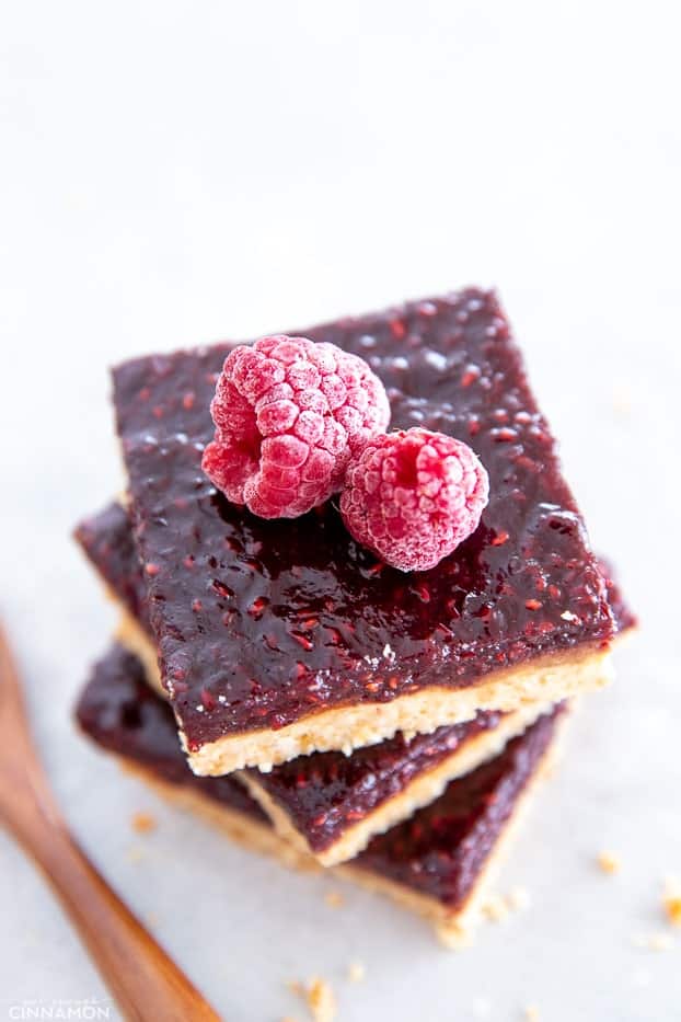 overhead shot of a stack of gluten-free raspberry almond butter bars topped with fresh raspberries