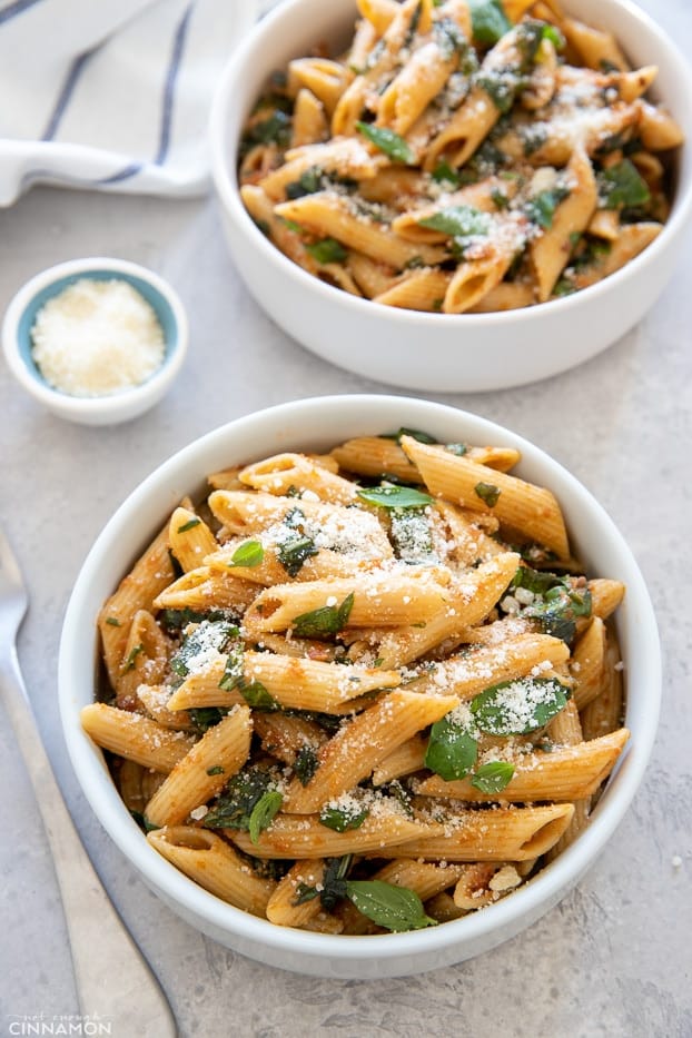 overhead shot of two bowls with easy sun-dried tomato pasta sprinkled with parmesan cheese