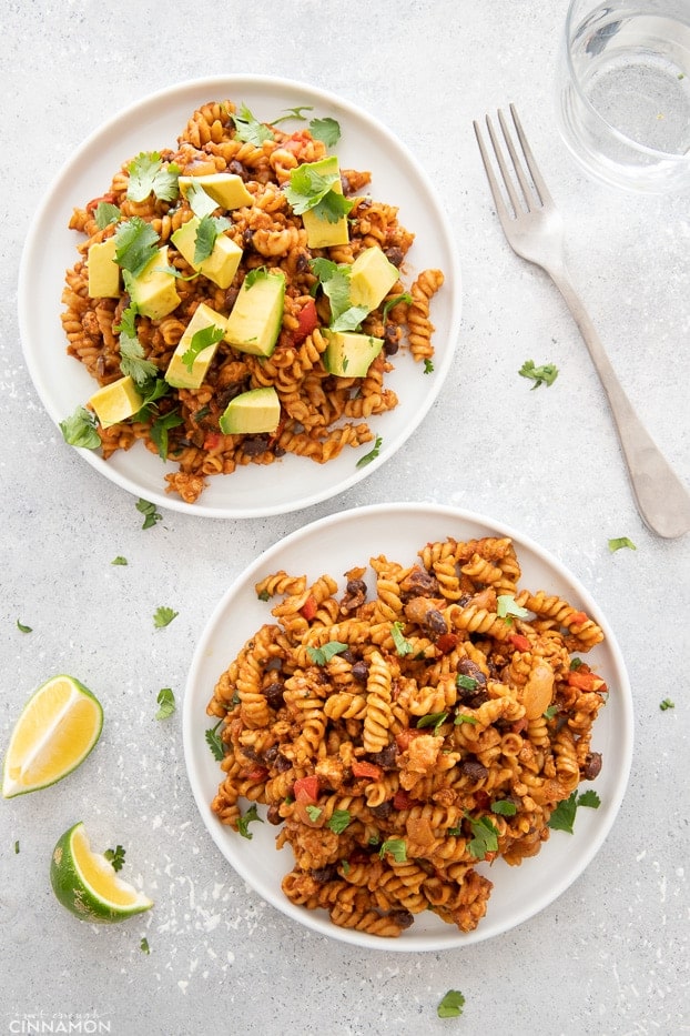 overhead shot of two plates of easy one-pot Taco Pasta made with ground turkey topped with cilantro andavocado 