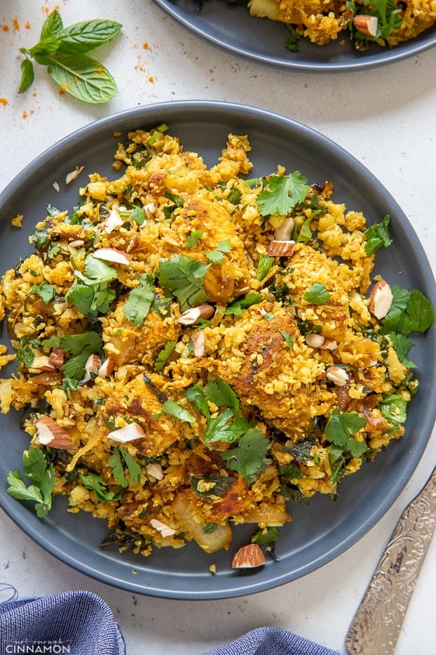 overhead shot of a blue plate with Indian paleo cauliflower rice stir-fry with chicken 