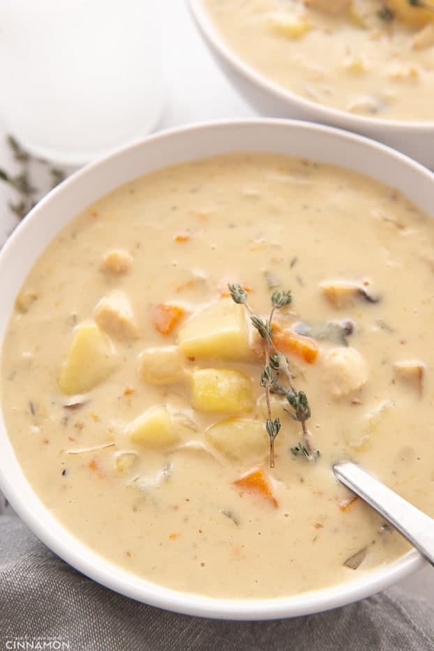 overhead shot of a bowl of the best creamy Whole30 chicken pot pie soup with a spoon inserted into the bowl