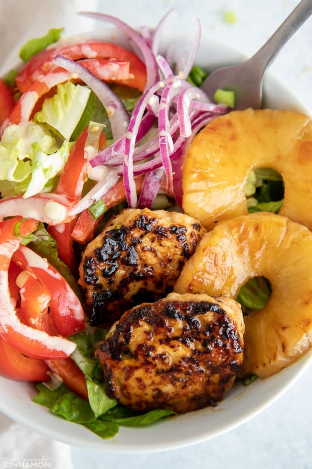 overhead close-up of a healthy Hawaiian chicken burger bowl with juicy chicken patties and charred pineapple rings 