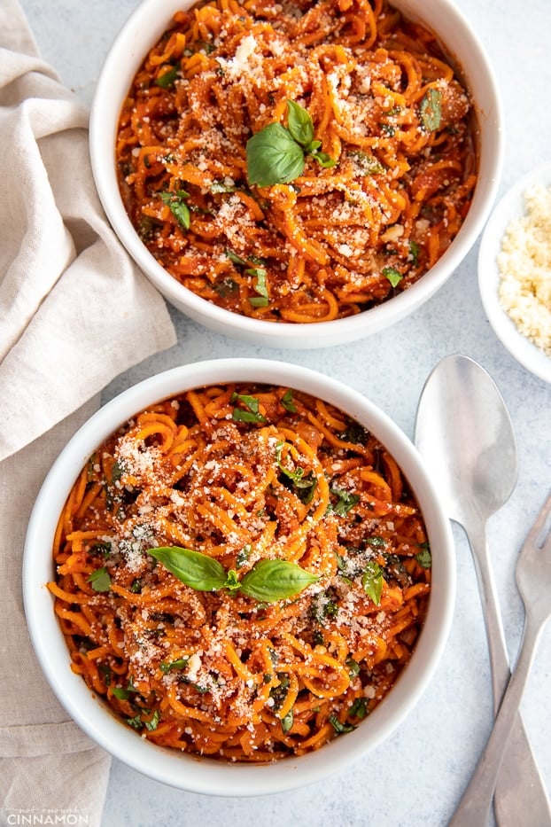 overhead shot of two Italian sweet potato noodle bowls sprinkled with basil and parmesan cheese