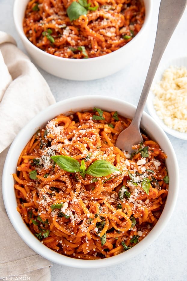 overhead shot of sweet potato noodles with Italian tomato sauce in a white bowl