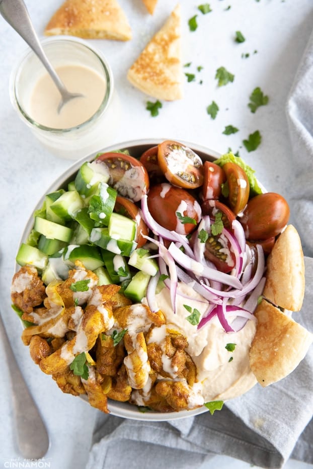 overhead shot of a healthy Lebanese Chicken Shawarma Bowl with homemade Tahini Sauce and pita chips