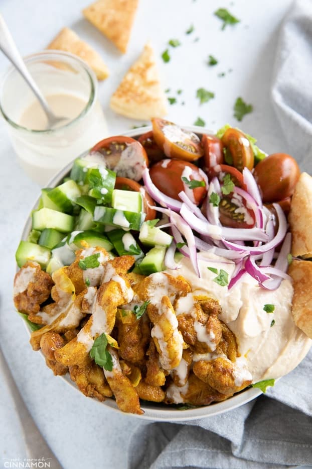 overhead shot of a homemade healthy chicken shawarma bowl drizzled with tahini sauce