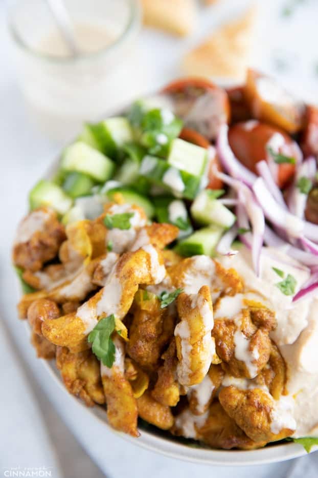 close-up of a healthy Middle Eastern Chicken Shawarma bowl with hummus, salad and tahini sauce