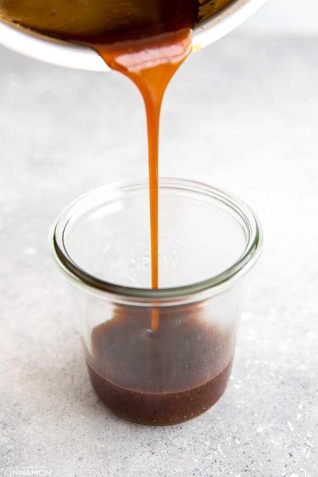 homemade healthy Whole30 teriyaki sauce being poured from a saucepan into a jar 