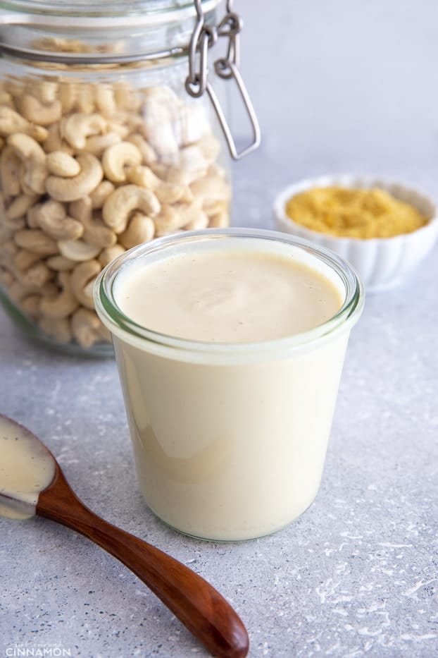 side view of a small container with vegan cashew alfredo sauce