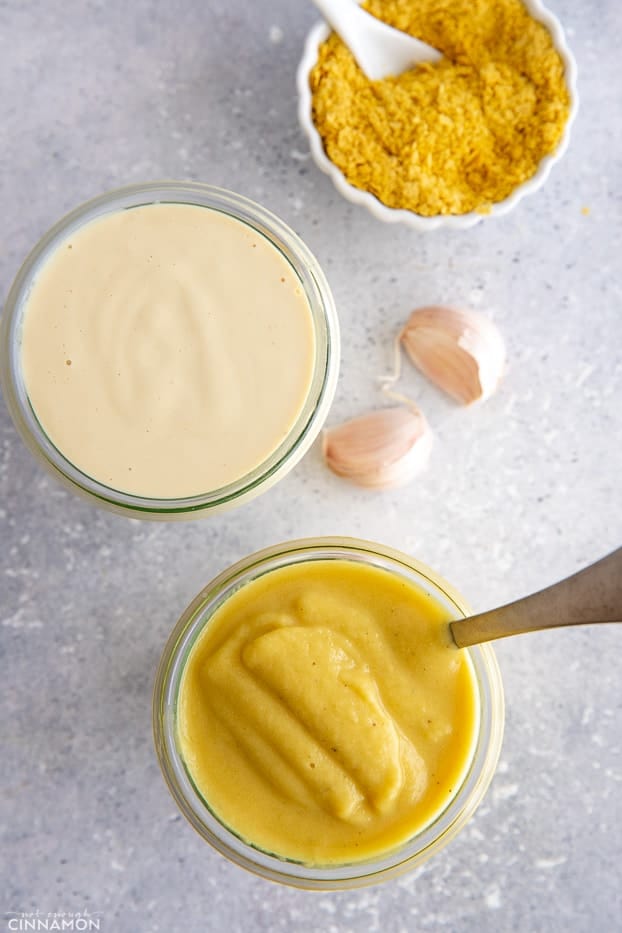 overhead shot of cauliflower alfredo sauce and cashew alfredo sauce in two glass jars