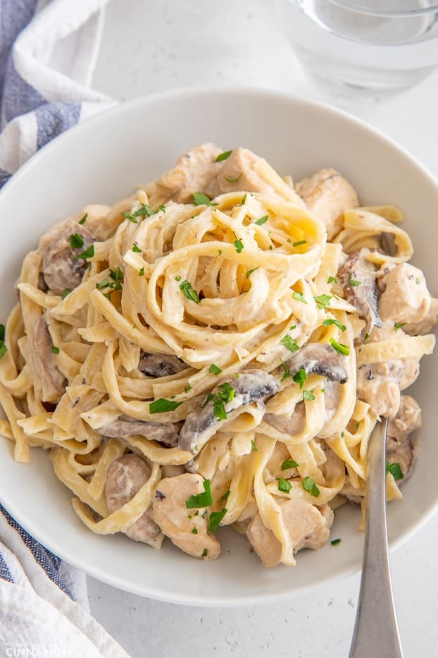 a serving of homemade dairy-free Fettuccine Alfredo with Chicken and Mushrooms sprinkled with parsley