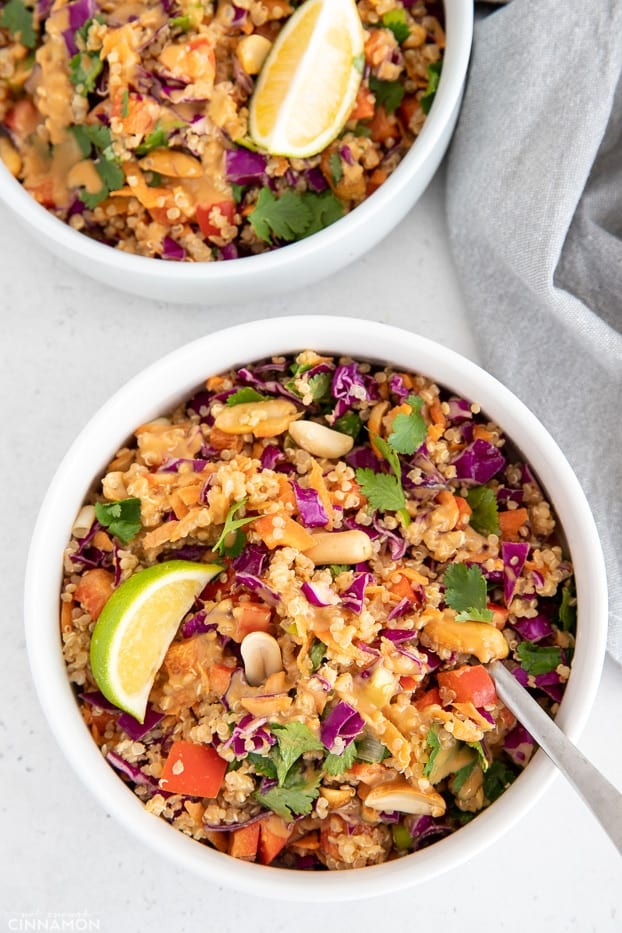 overhead shot of a healthy Thai Quinoa Salad drizzled with creamy peanut dressing