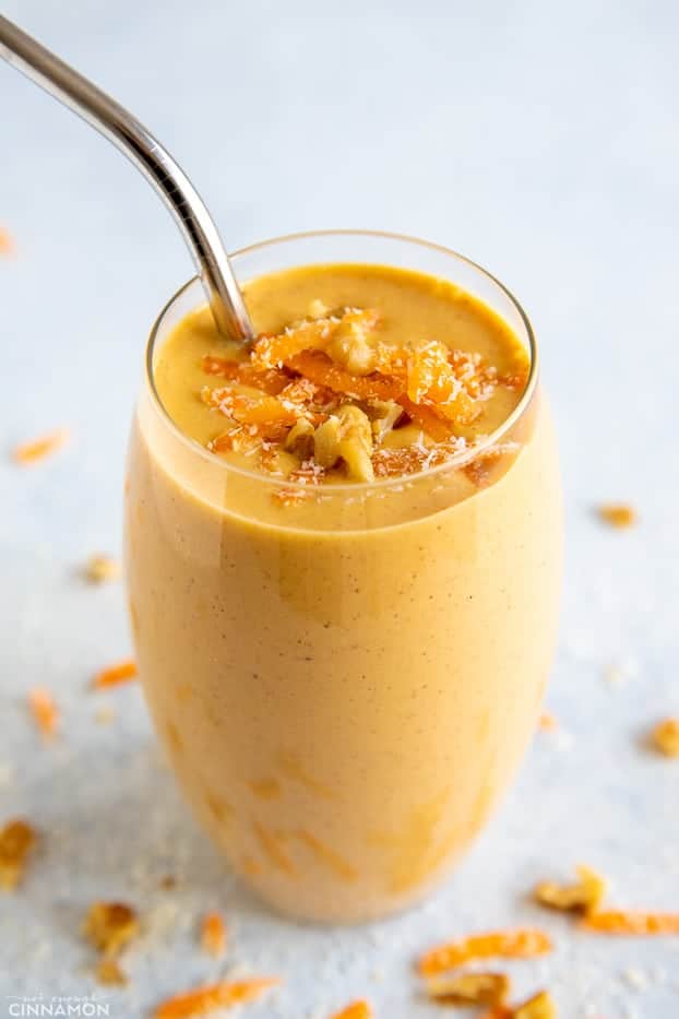 a tall glass filled with healthy carrot cake smoothie with a metal straw