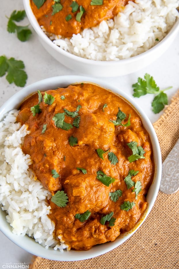 overhead shot of two white bowls filled with paleo butter chicken and rice