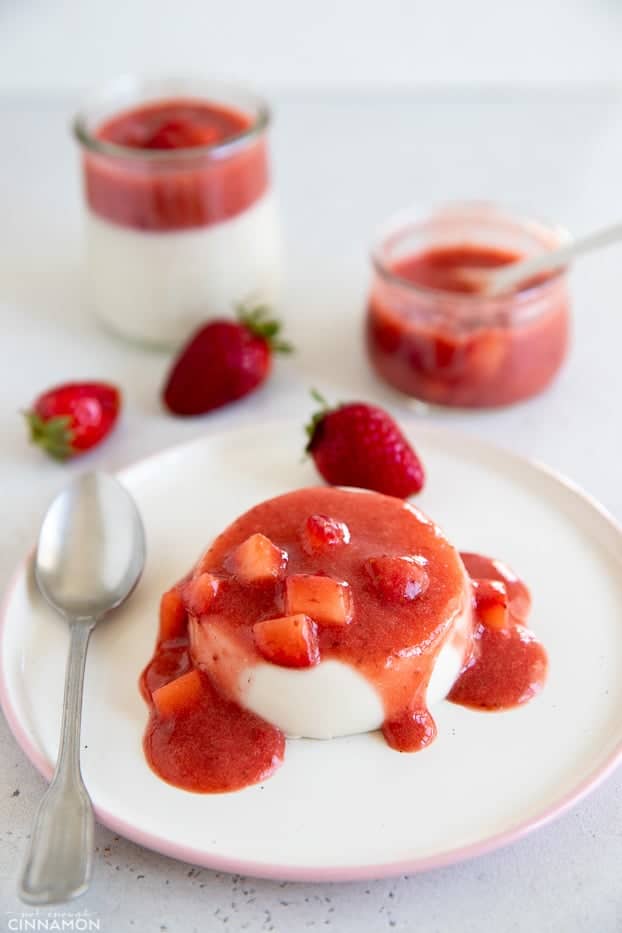 side view of a serving of coconut milk panna cotta topped with strawberry sauce