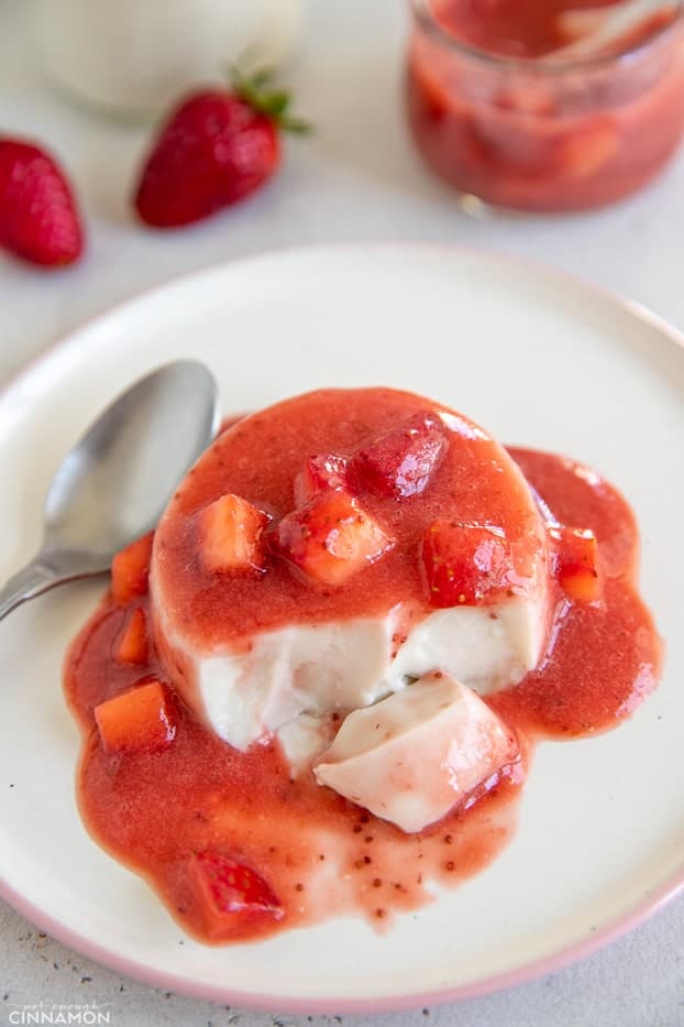 a half-eaten coconut milk panna cotta covered with homemade refined sugar-free strawberry compote 