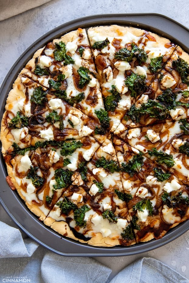 overhead shot of a gluten-free kale pizza in a pizza tray 