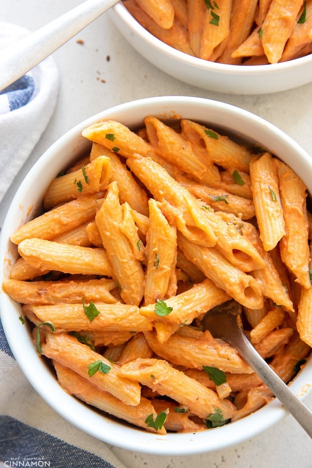 overhead close-up of vegan penne vodka sprinkled with parsley 