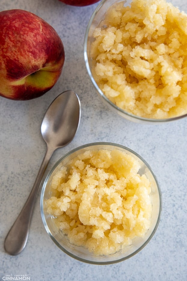 homemade peach granita in a small glass with a spoon on the side