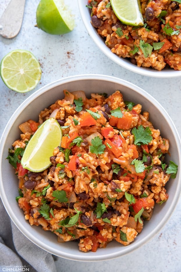 overhead shot of a healthy Mexican Ground Turkey Rice Bowl served with lime wedges 