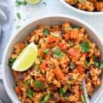 overhead shot of Mexican rice and ground turkey bowl topped with lime wedge and cilantro