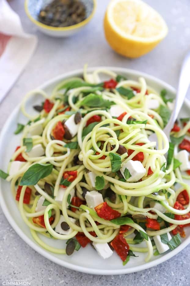 overhead shot of a plate of zucchini salad made with zoodles, sundried tomatoes and goat cheese 