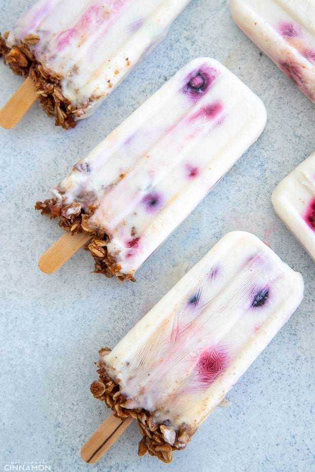 overhead shot of homemade healthy yogurt popsicles with berries and granola