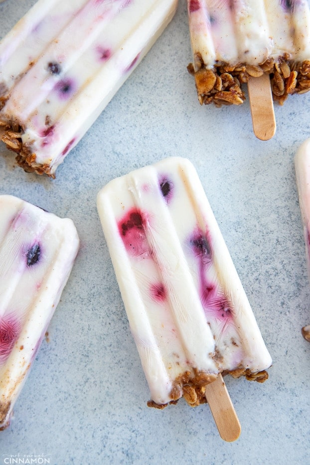 overhead shot of healthy Berry Greek Yogurt Popsicles with Granola on a kitchen counter 