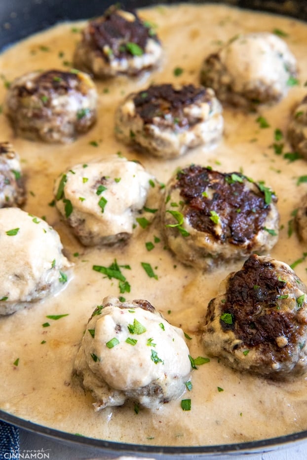 paleo almond flour beef meatballs in a skillet with creamy dairyfree gravy