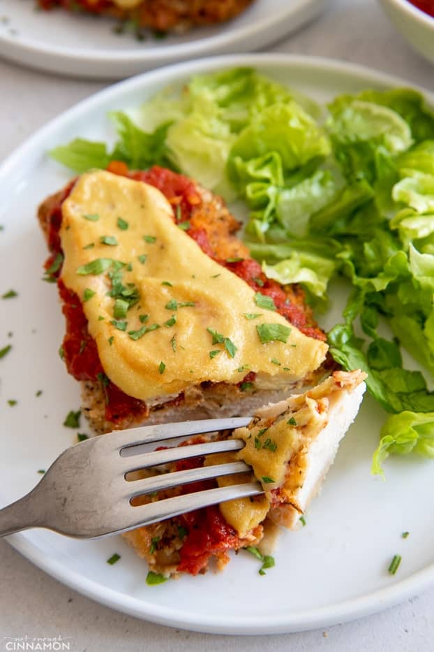 a fork piercing into a piece of homemade chicken parmesan