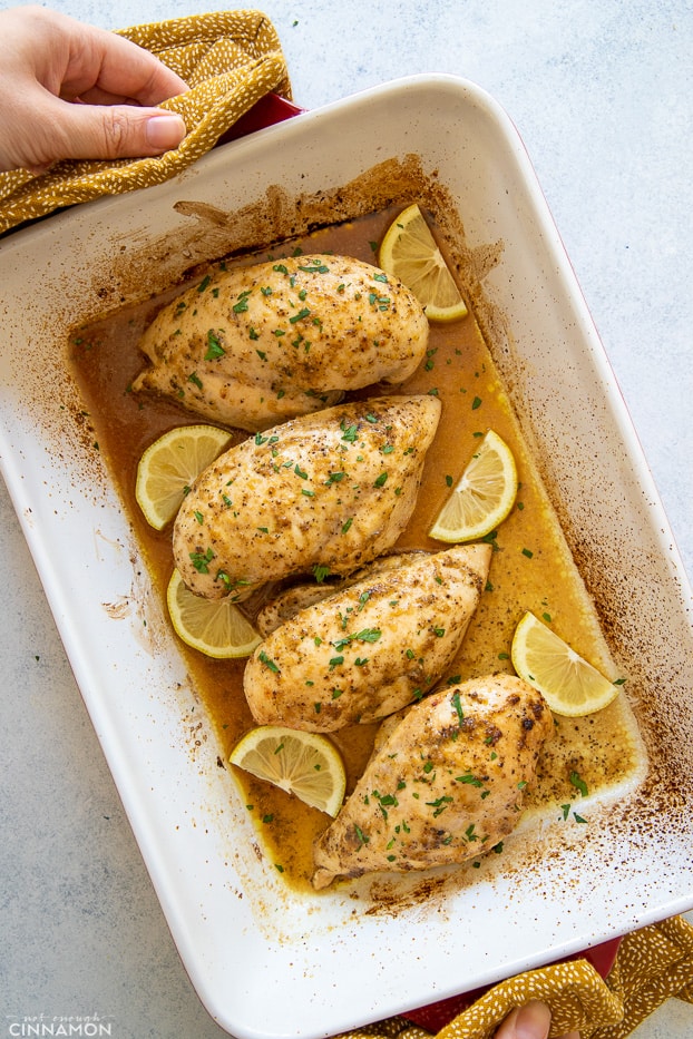 overhead shot of baked lemon pepper chicken in a white casserole dish 