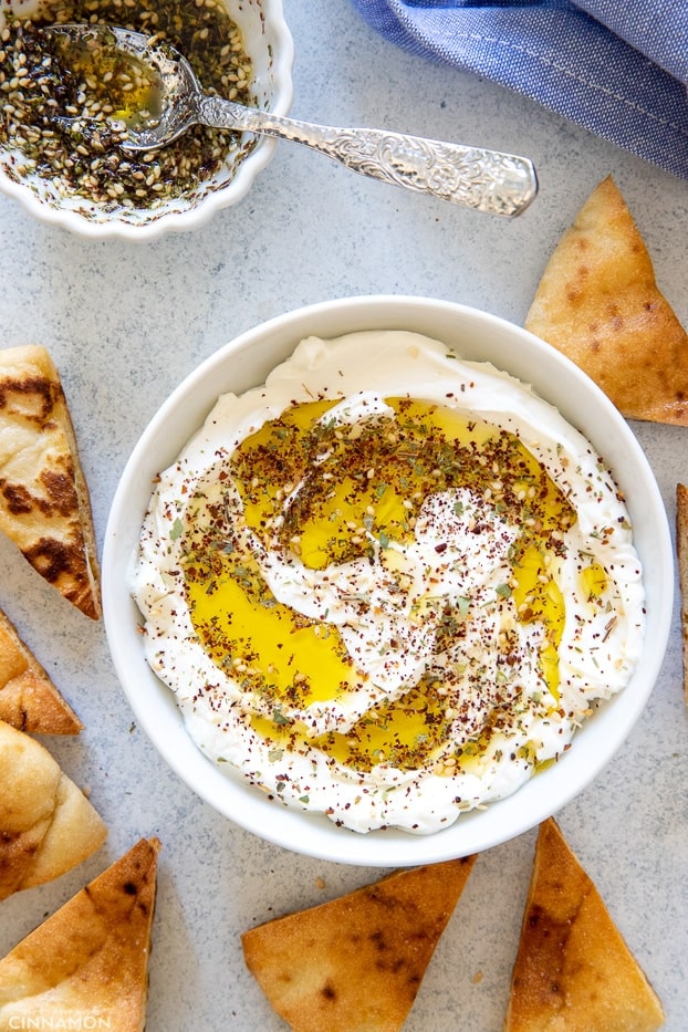 overhead shot of a bowl with labneh sprinkled with zaatar and drizzled with olive oil 