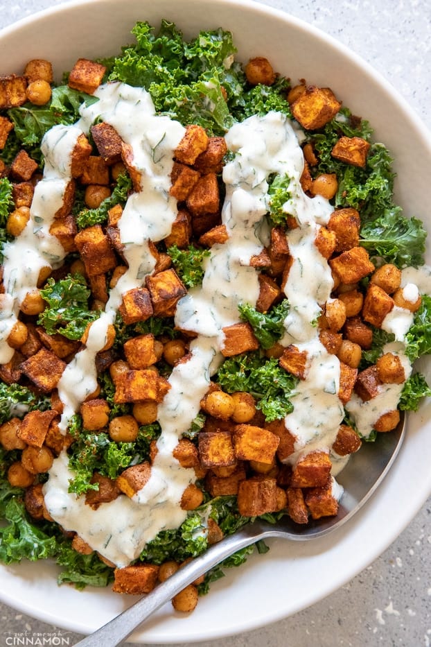 a chickpea sweet potato salad with kale drizzled with Greek yogurt dressing 