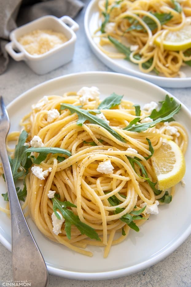 close-up of a plate with lemon pasta with arugula and crumbles feta 