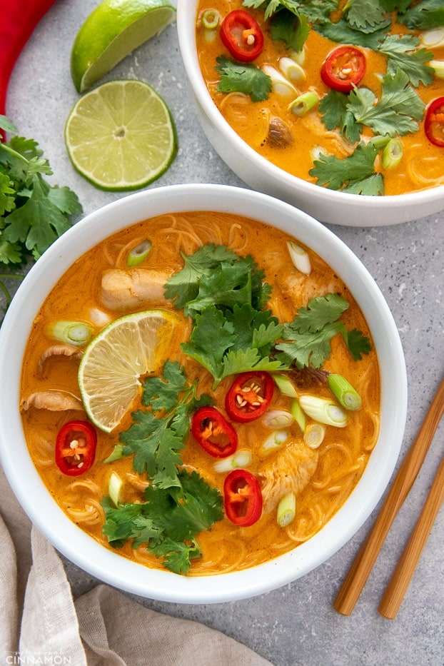 two white bowls with Red Curry Thai Noodle Soup with Chicken and Coconut Milk 