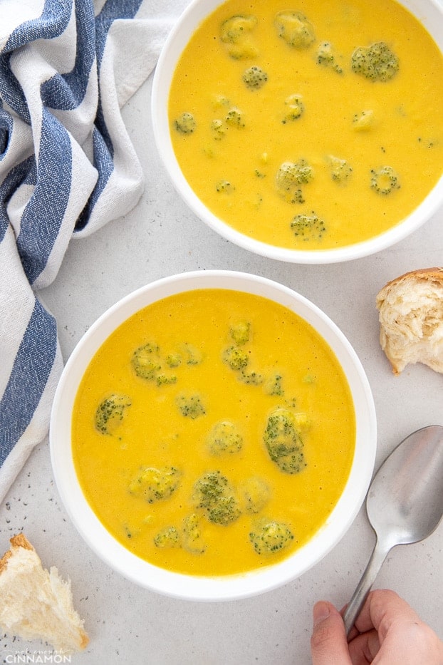 overhead shot of two bowls of vegan cheese soup with broccoli florets