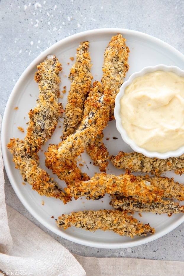 overhead shot of a plate of baked portobello mushroom fries served with a side dish of aioli 