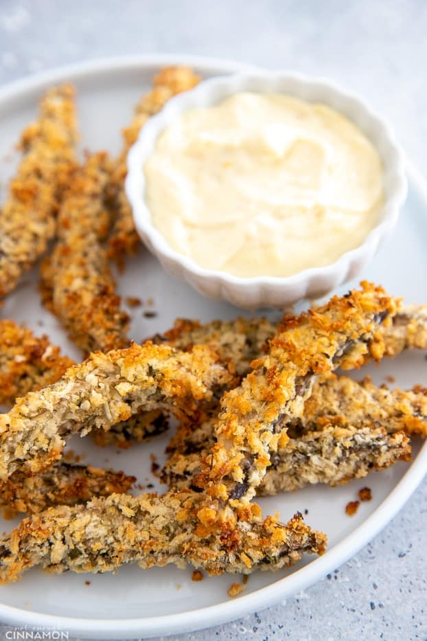 side view of a serving of baked Portobello Mushroom Fries served with aioli