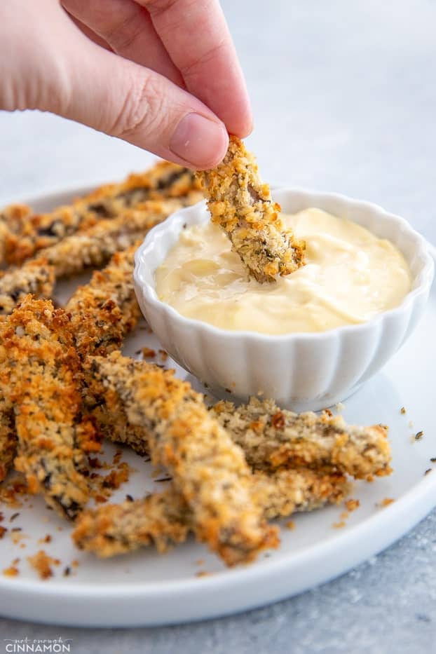 a healthy baked portobello mushroom fry being dipped into homemade aioli