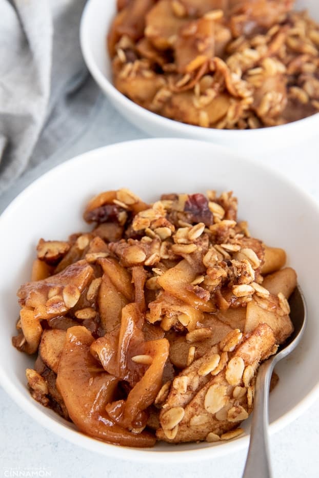 a bowl with easy healthy apple crisp with a spoon on the side 