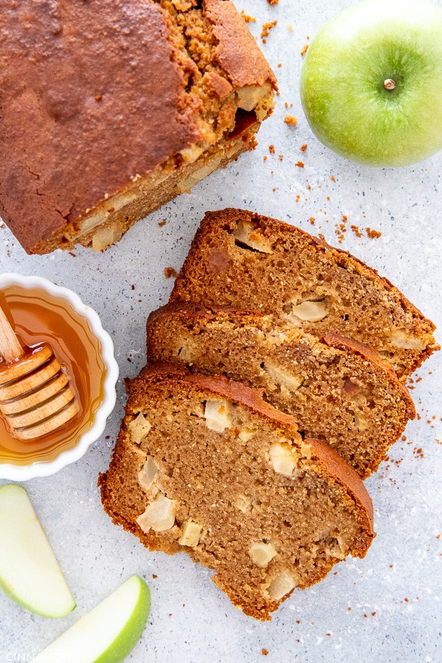 a sliced loaf of paleo honey apple bread with apple slices on the side 