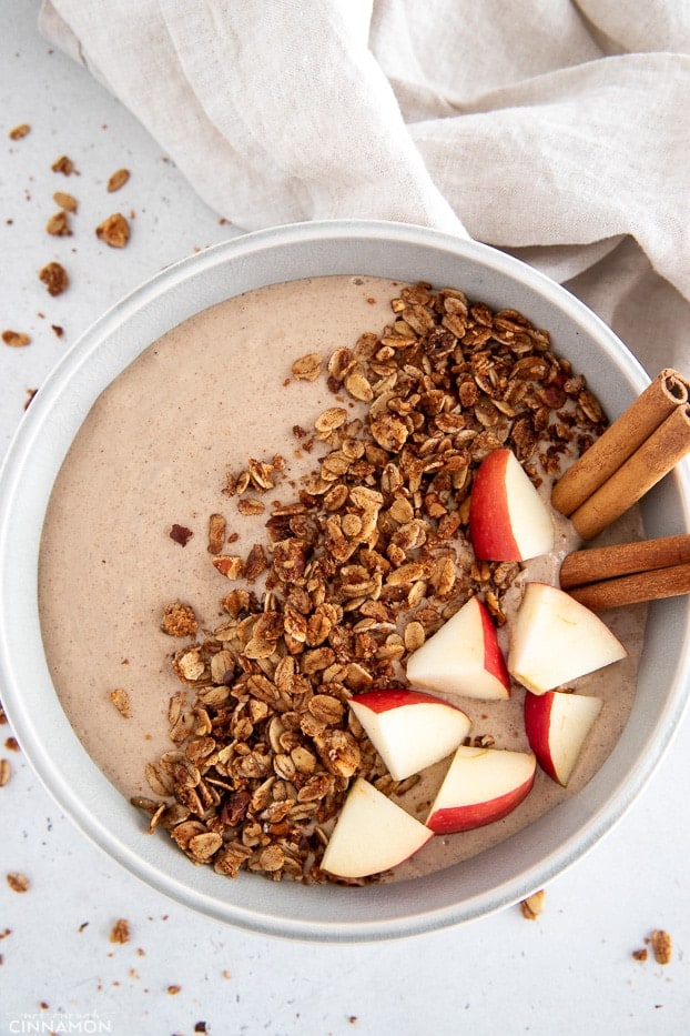 apple pie smoothie bowl topped with granola, cinnamon and apple chunks