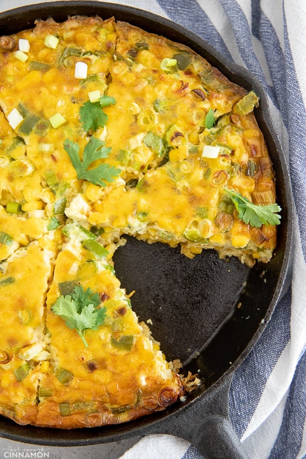 overhead shot of a sliced chile corn casserole in a black skillet 