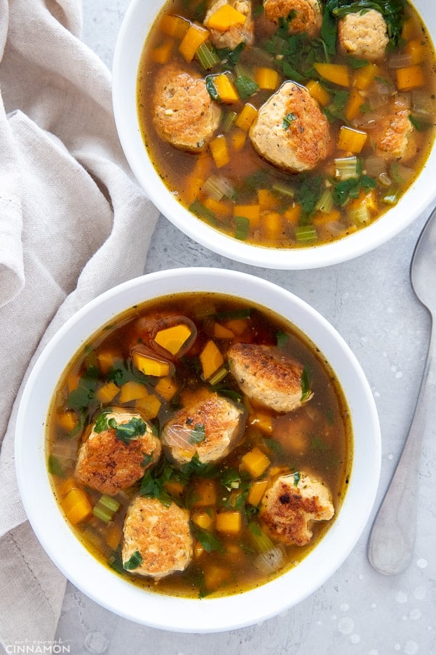 overhead shot of two bowls of Italian Wedding Soup with chicken meatballs and diced veggies 